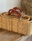 Set of woven baskets with handles on a wooden surface