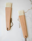 2 wooden pastry brushes on marble counter top