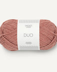 Ball of pink yarn with a white label on a light gray background