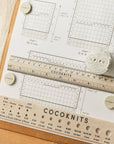 Knitting chart with ruler and measurement tools on a beige background