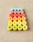 Colorful foam beads arranged in a pattern on a beige fabric background