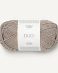 A skein of beige Sandnes Garn Duo yarn with a label in the center displaying the brand and product name.