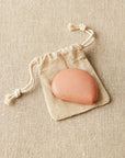 A clay-colored measuring tape with a metal tab, packaged individually in a linen drawstring bag with the Cocoknits logo.