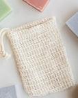 Agave soap saver bag laid flat among colorful handmade soap bars