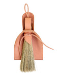 Natural leather dustpan and broom on a white background