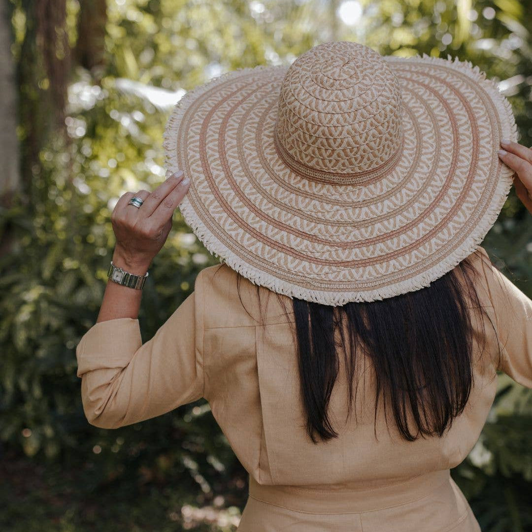Person wearing a wide-brimmed straw hat outdoors