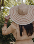 Person wearing a wide-brimmed straw hat outdoors