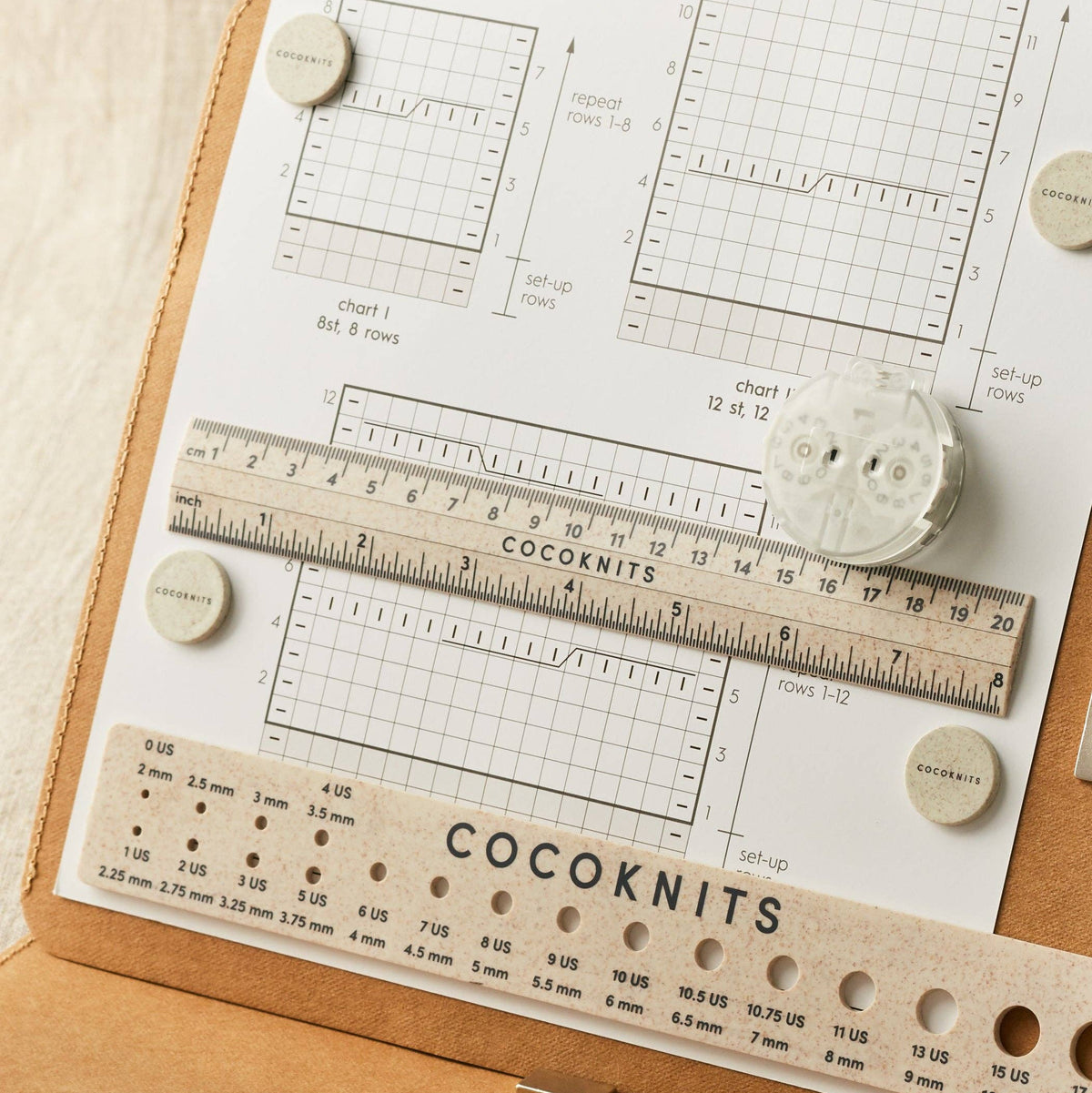 Knitting chart with ruler and measurement tools on a beige background